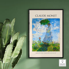 Monet Woman with Parasol Madame Monet Son Impressionist Art Print Poster framed on a green wall with plants.