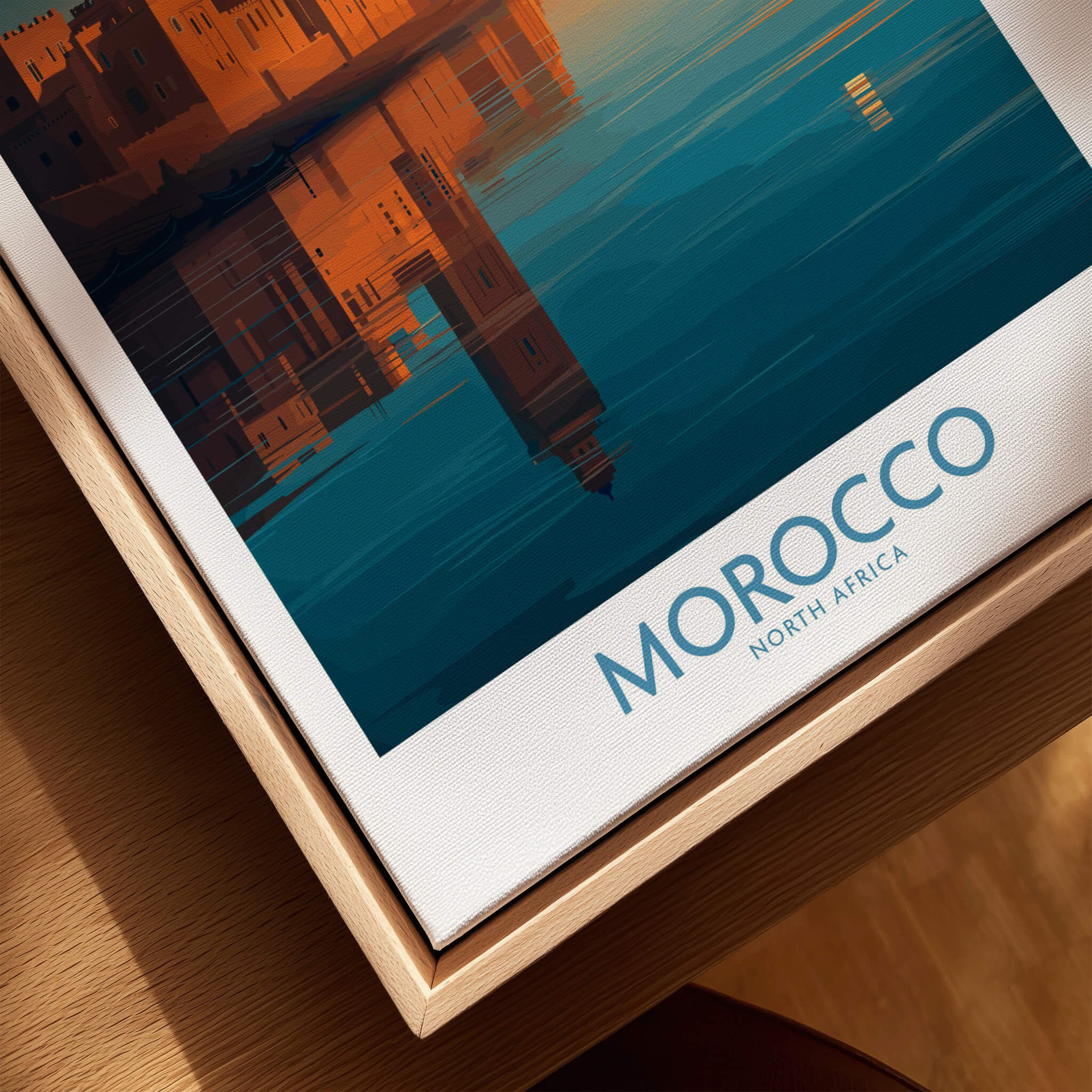Morocco Poster | North African Cityscape Sunset Canvas Print displayed on a wooden table, showcasing vibrant colors and reflections.