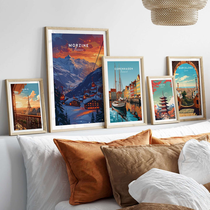 Framed ski posters including Morzine Print France displayed on a stylish shelf above a cozy bed with pillows.