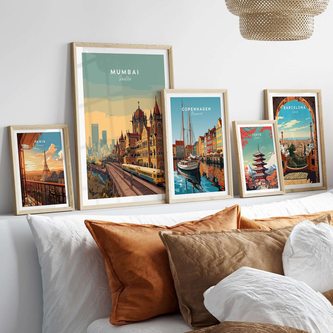 Framed posters of Mumbai, Copenhagen, and Barcelona on a stylish bed, showcasing vibrant city landscapes and landmarks.