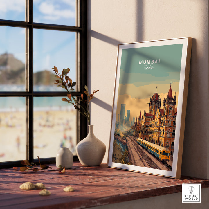 Mumbai Chhatrapati Shivaji Terminus art print displayed on a wooden table with a view of the beach.