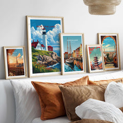 New England Art Print featuring a charming lighthouse alongside other travel posters on a stylish wall display.