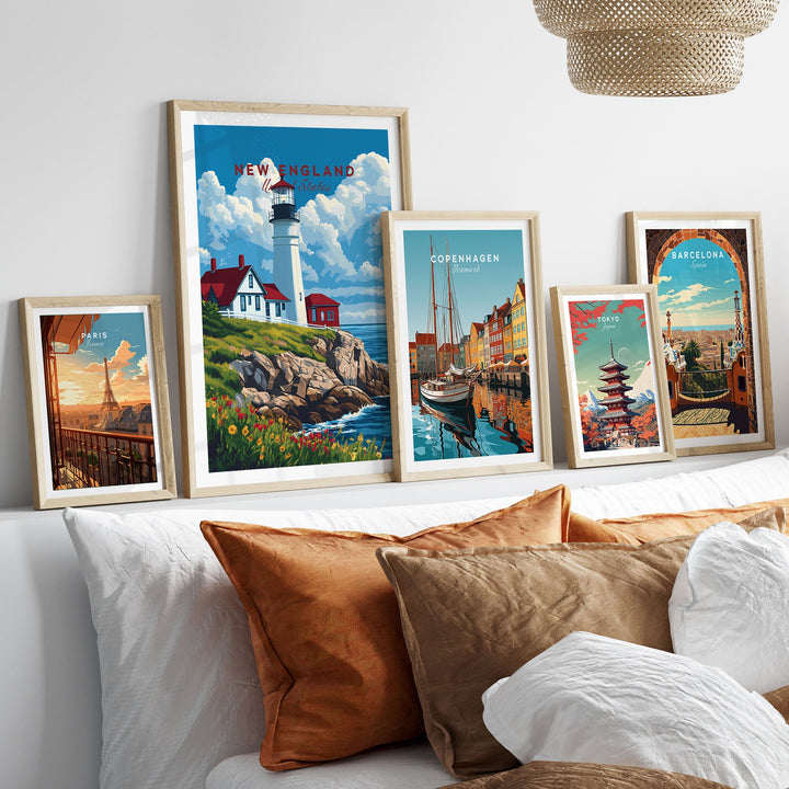 Collection of framed travel posters including New England lighthouse art print displayed above a cozy couch.