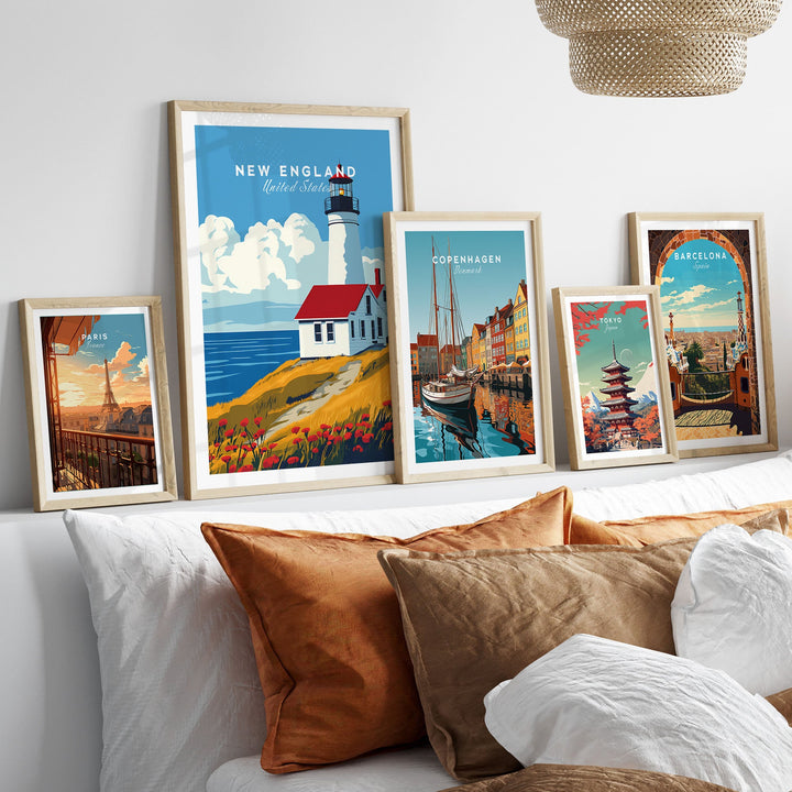 New England wall art with lighthouse, surrounded by framed travel posters of Copenhagen, Barcelona, and vibrant cityscapes.