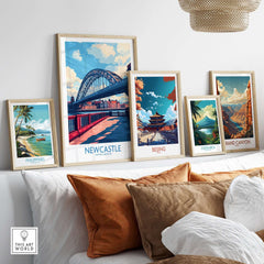 Newcastle Travel Poster displayed among other travel posters in a stylish living room setting.