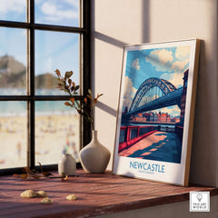 Newcastle Travel Poster displayed on a shelf with Tyne Bridge and beach view in the background.