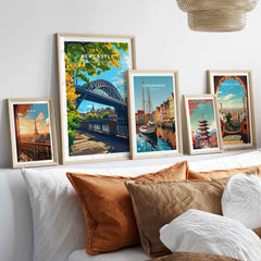 Newcastle upon Tyne Travel Print displayed among other travel prints in stylish frames on a cozy bed.