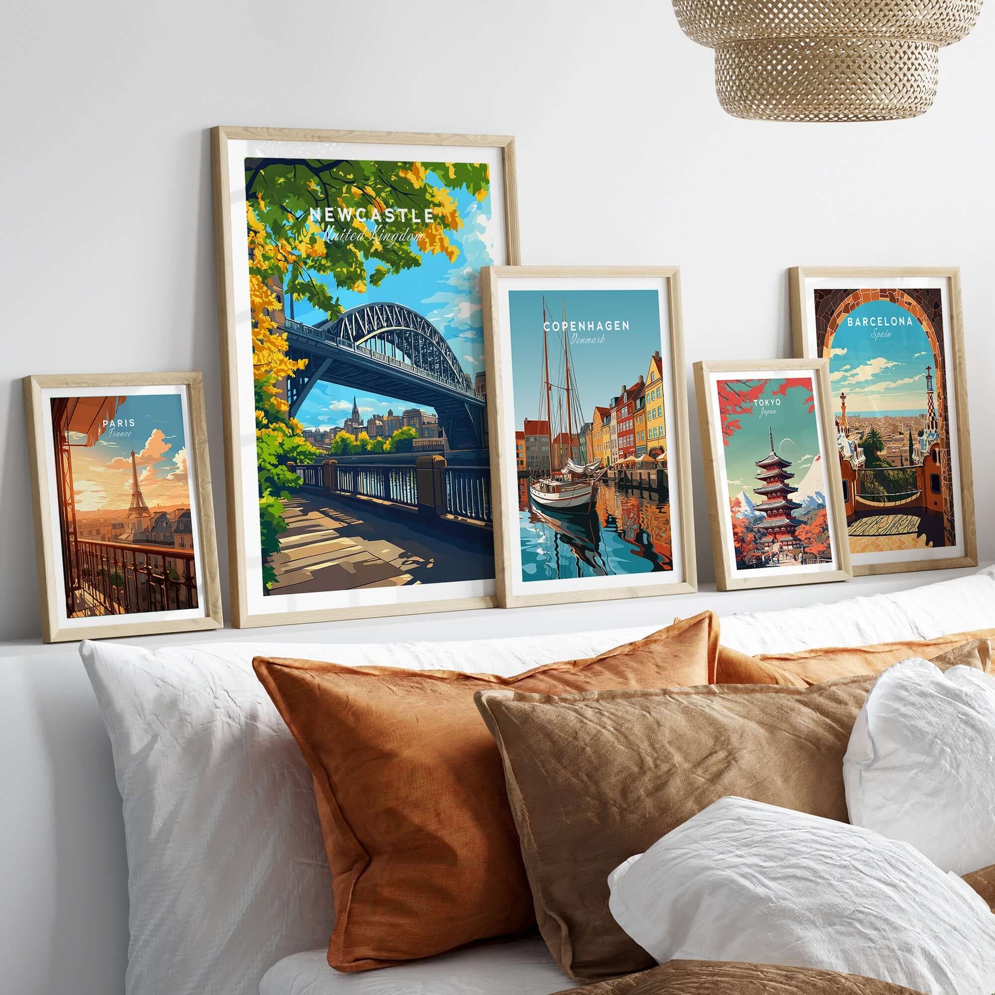 Newcastle upon Tyne Travel Print displayed among other travel prints in stylish frames on a cozy bed.