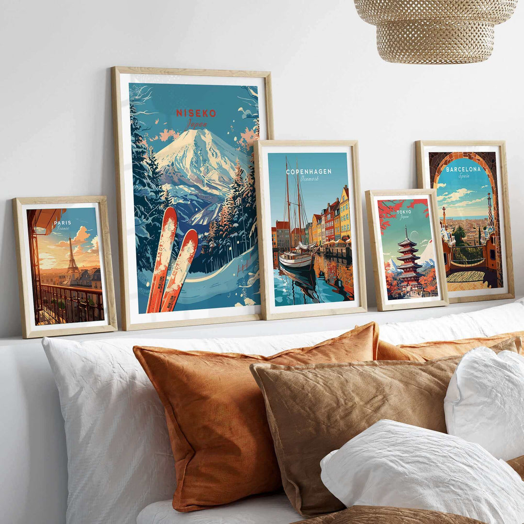 Framed travel-themed art prints featuring Niseko, Copenhagen, and Barcelona displayed on a stylishly decorated shelf.