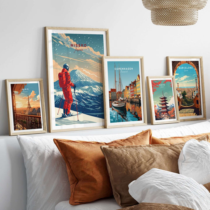 Niseko travel poster and framed city prints on a bed with decorative pillows, enhancing home decor with a travel theme.