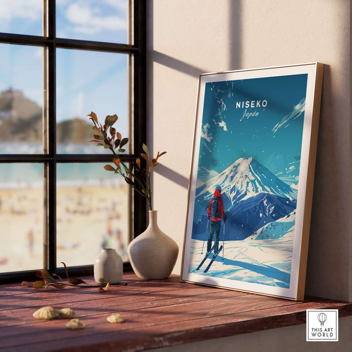 Framed Niseko Japan travel print on a windowsill, featuring a skier and snow-capped mountains.