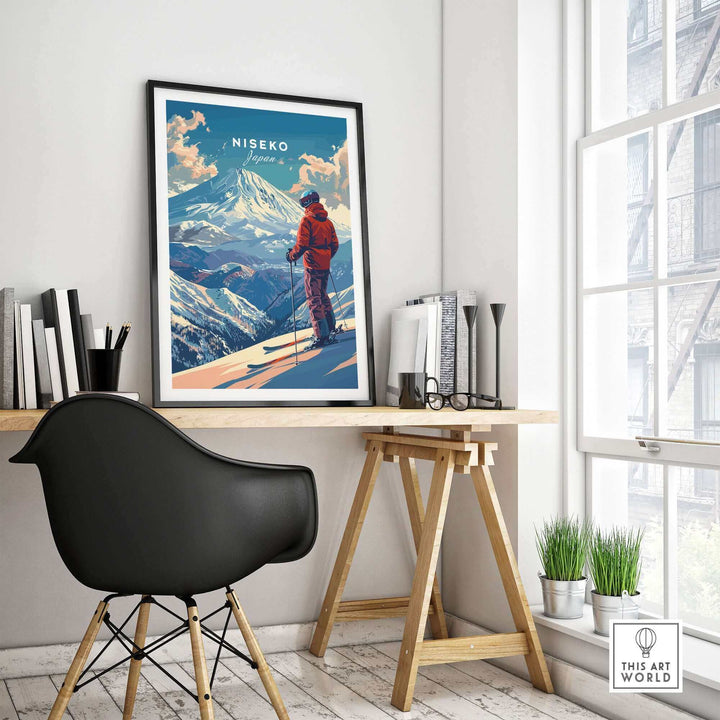 Modern interior with framed Niseko wall art of a skier in Japan, set on a minimalist desk with books and window view.