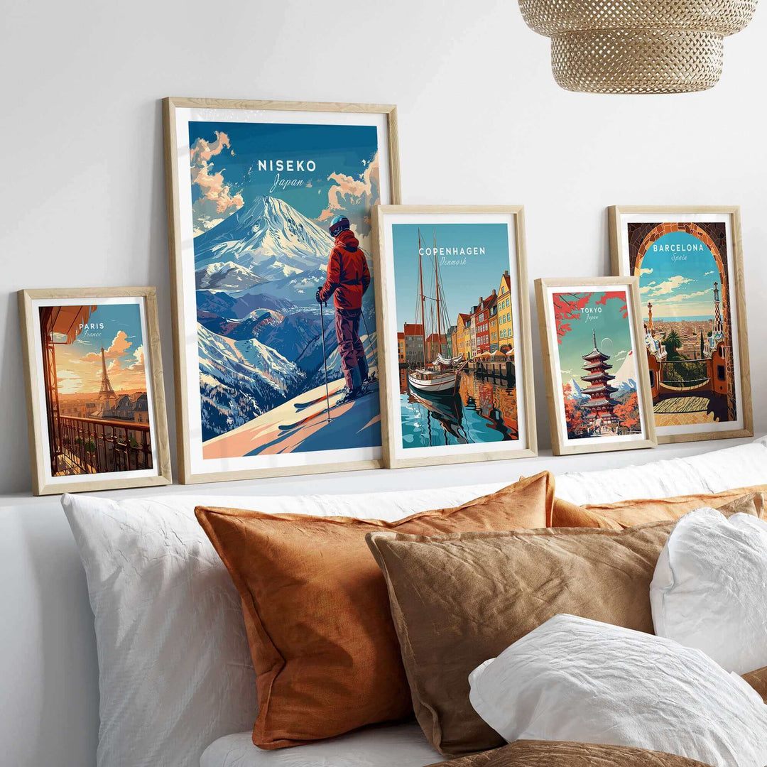 Framed Niseko Japan wall art among diverse travel-themed artworks displayed on a white shelf above a cozy couch.