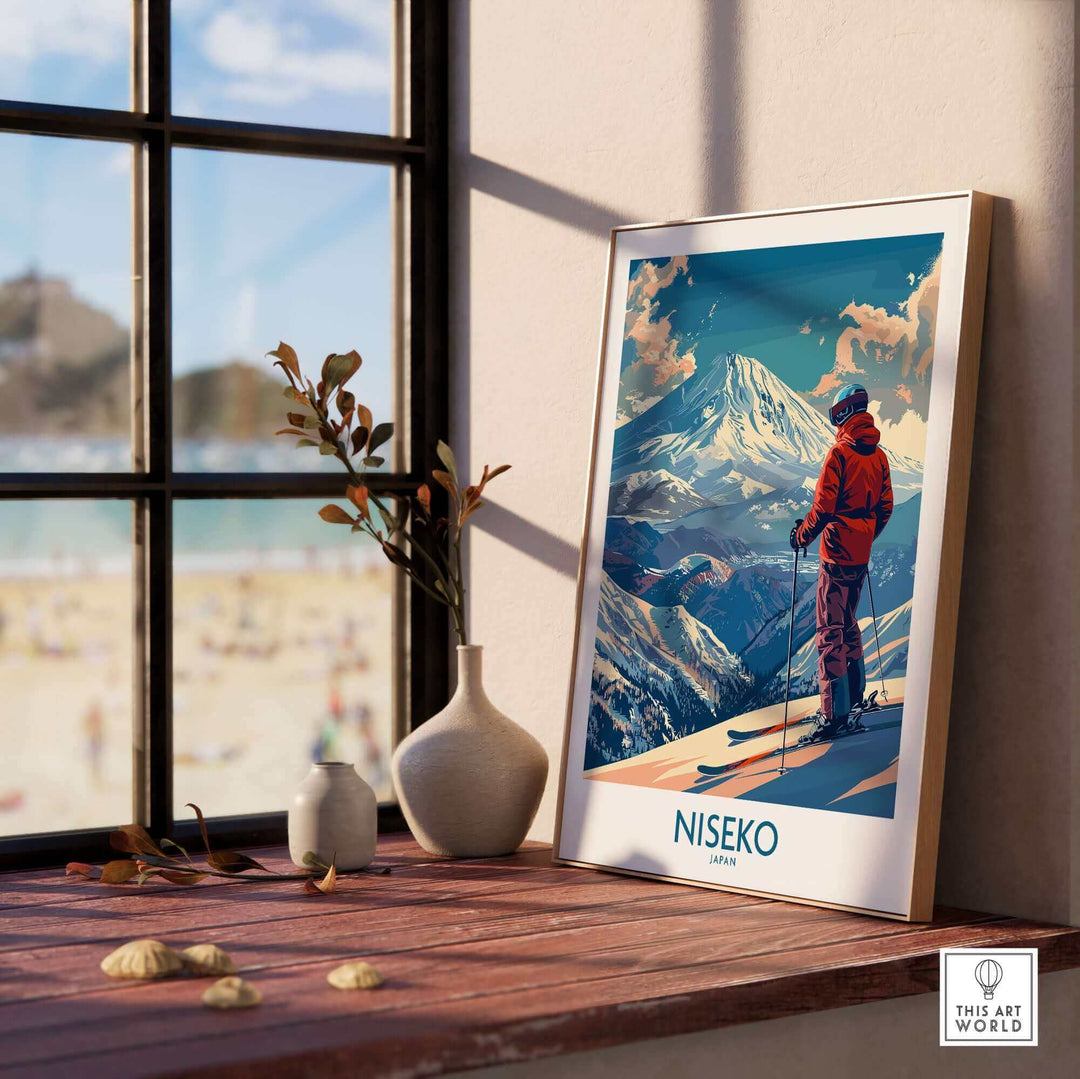 Niseko wall art print featuring ski scene in Japan, with snowy mountains and skier, displayed on a windowsill with natural light.