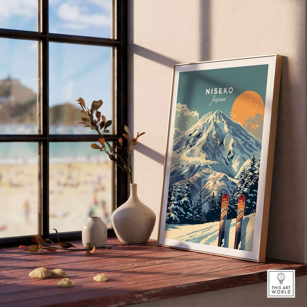 Framed Niseko ski print wall art displayed on a sunlit windowsill with scenic snow-covered mountain and colorful sky.