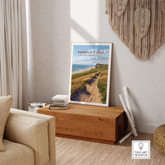 Norfolk Coast Poster displayed in a cozy living room, featuring the serene landscape of the Norfolk coastline.