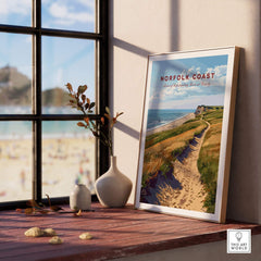 Norfolk Coast Poster framed on a windowsill showcasing sandy paths and stunning coastal views.