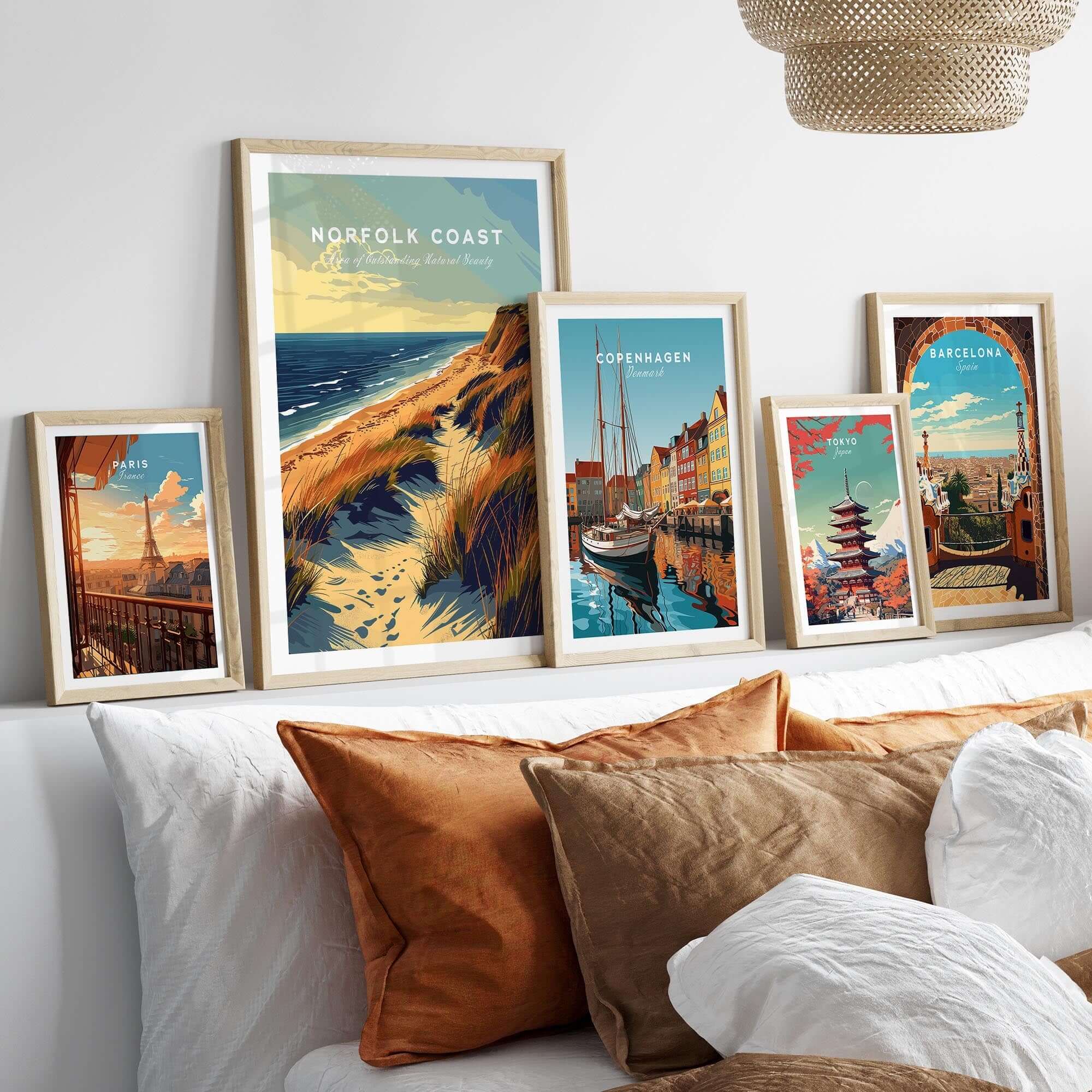 Norfolk Coast Poster Print displayed among framed art prints on a cozy sofa with decorative pillows.