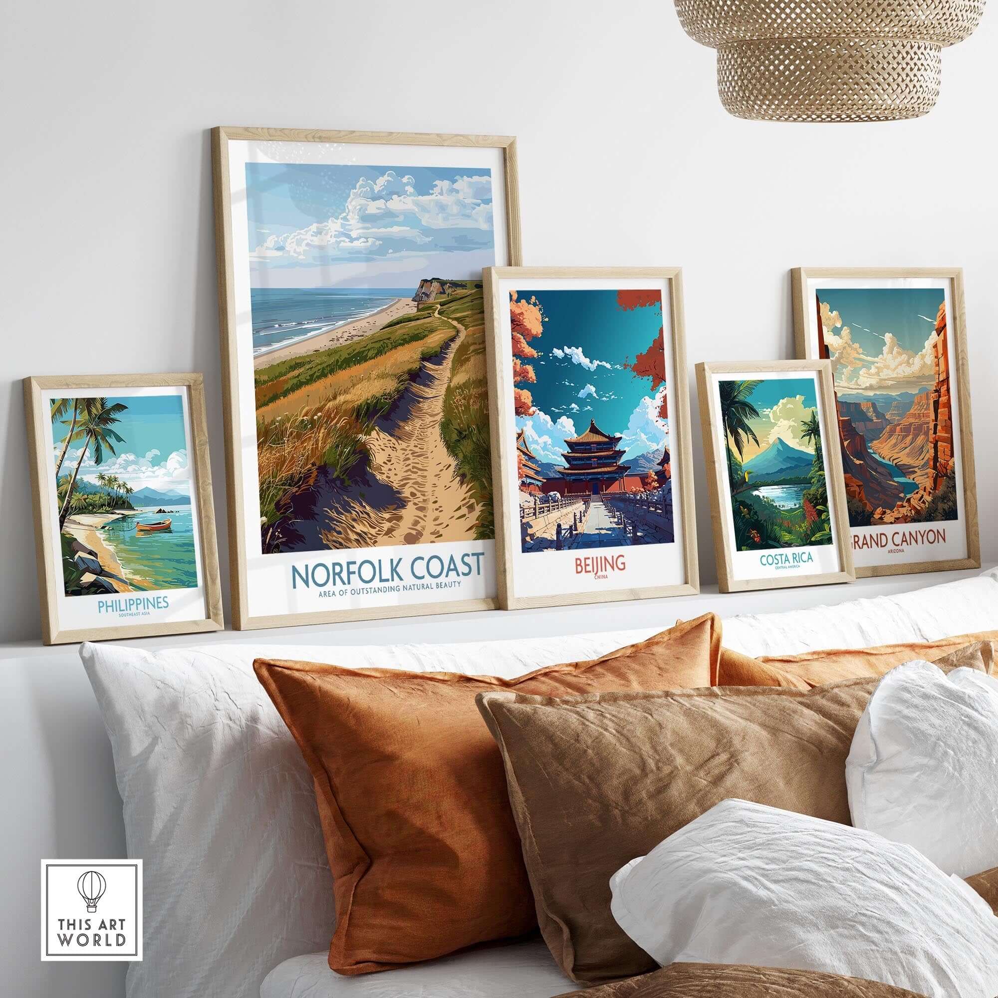 Norfolk Coast Print showcased among various travel art prints on a stylish couch with natural decor.