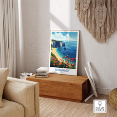 Normandy Poster France displayed in a cozy living room, showcasing vibrant coastal scenery and flowers.