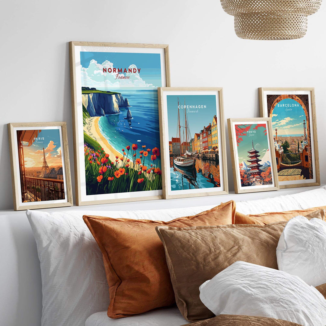 Framed Normandy print among other city artwork, showcasing coastal scenery and vibrant flowers in a stylish interior setting.