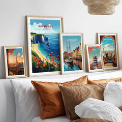 Normandy Print France artwork displayed with other city prints on a stylish bed, showcasing beautiful wall art.