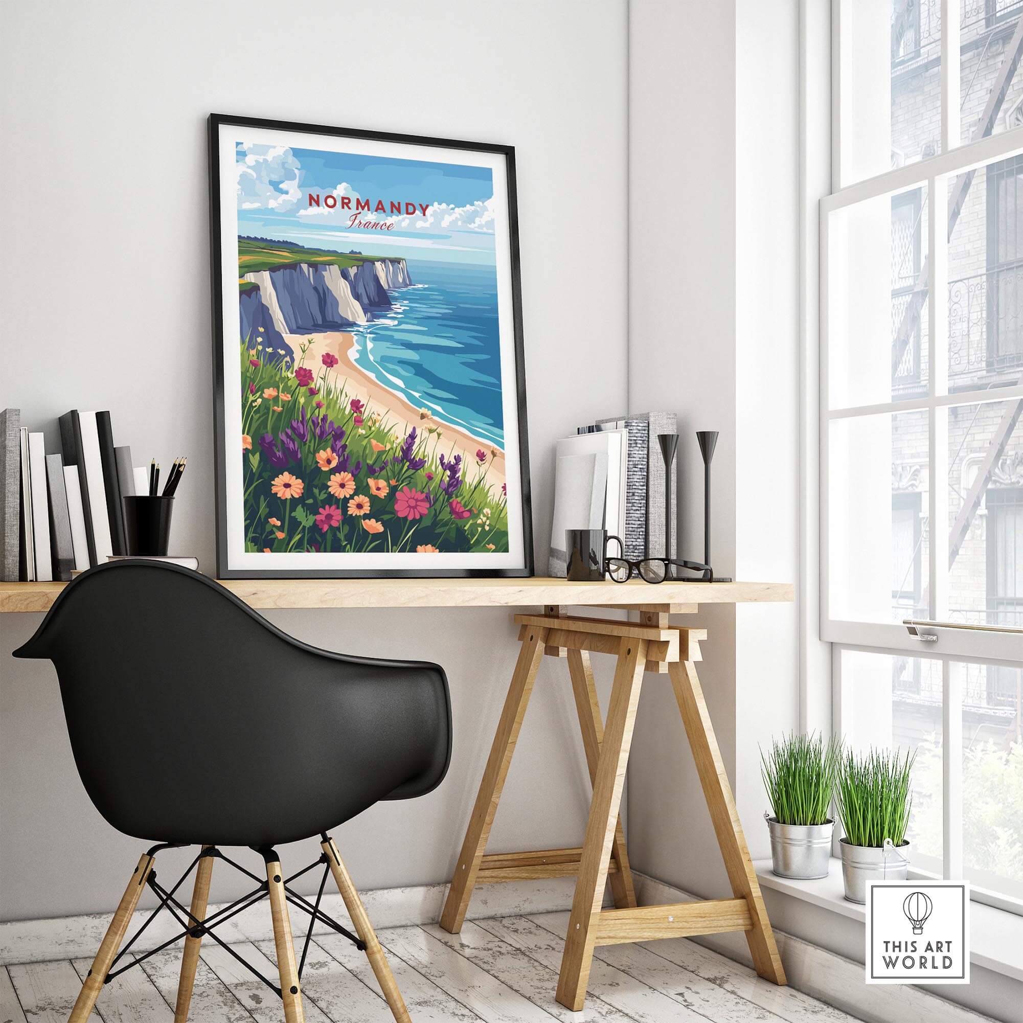 Normandy Travel Print displayed in a stylish home office, featuring coastal scenery and vibrant flowers.