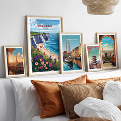 Normandy Travel Print showcased among other travel prints on a stylish wall in a cozy living space.