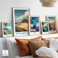 Northumberland Wall Art Poster -  Bamburgh Castle displayed among other travel posters on a stylish couch.