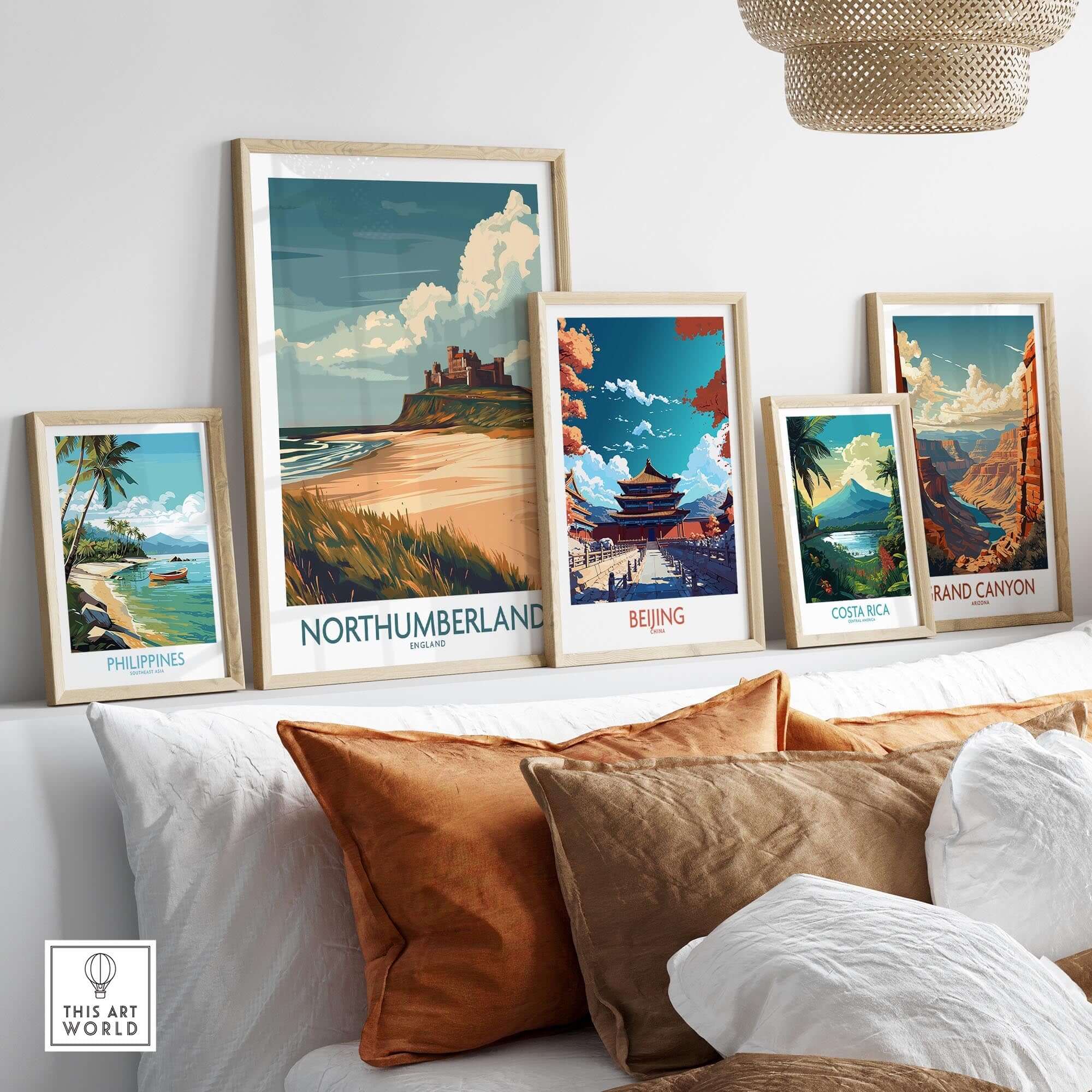Northumberland Wall Art Poster -  Bamburgh Castle displayed among other travel posters on a stylish couch.