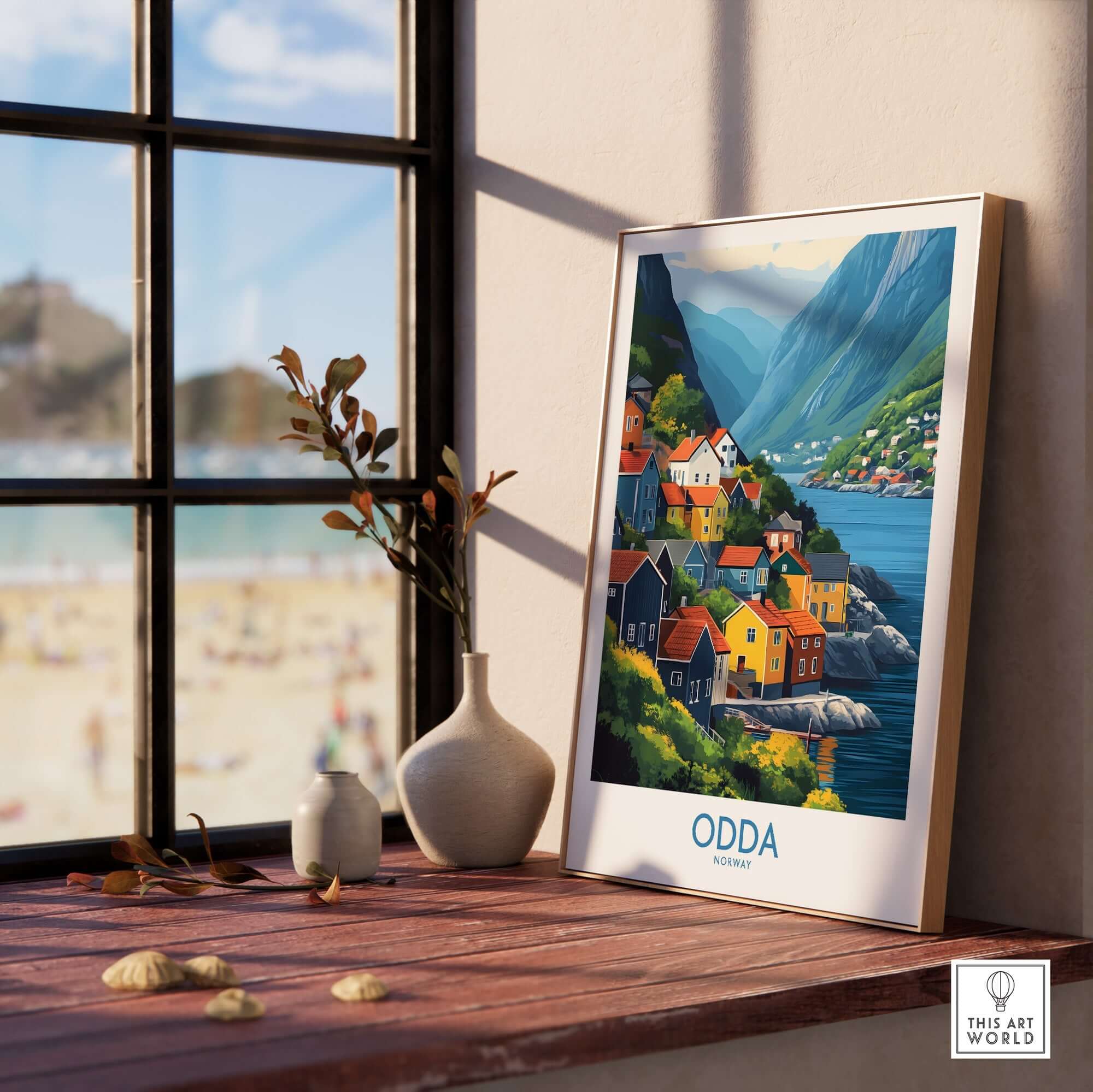 Odda Poster Norway displayed on a wooden table near a window, showcasing colorful houses and scenic mountains.