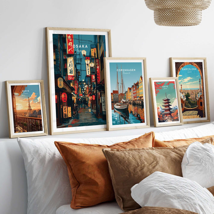 Framed Osaka travel print and cityscape posters on a decorative shelf above stylish cushions.