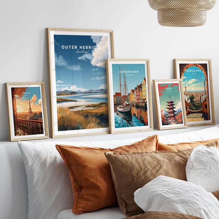 Framed travel prints including Outer Hebrides, Copenhagen, and Barcelona on a stylish wall above a cozy bed.
