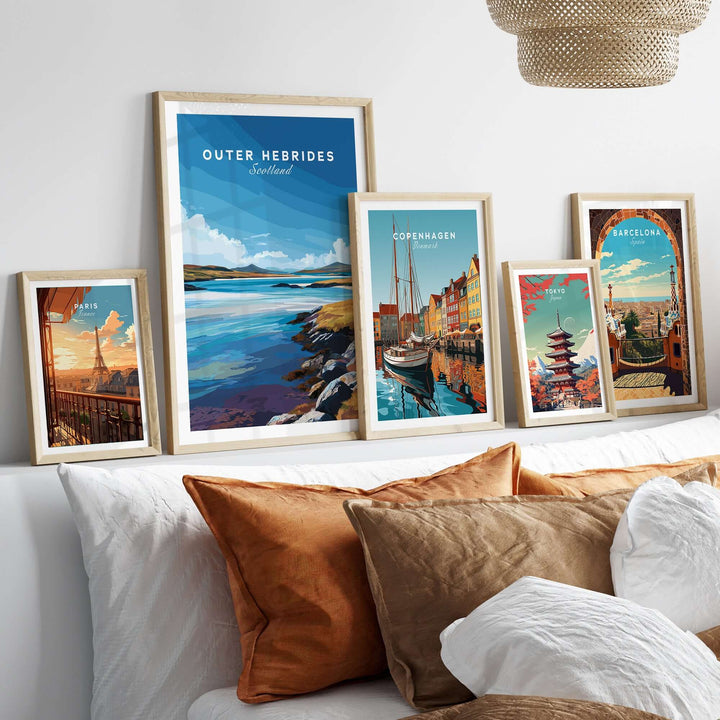 Framed Outer Hebrides wall art and city posters displayed on a cozy bed with decorative pillows.