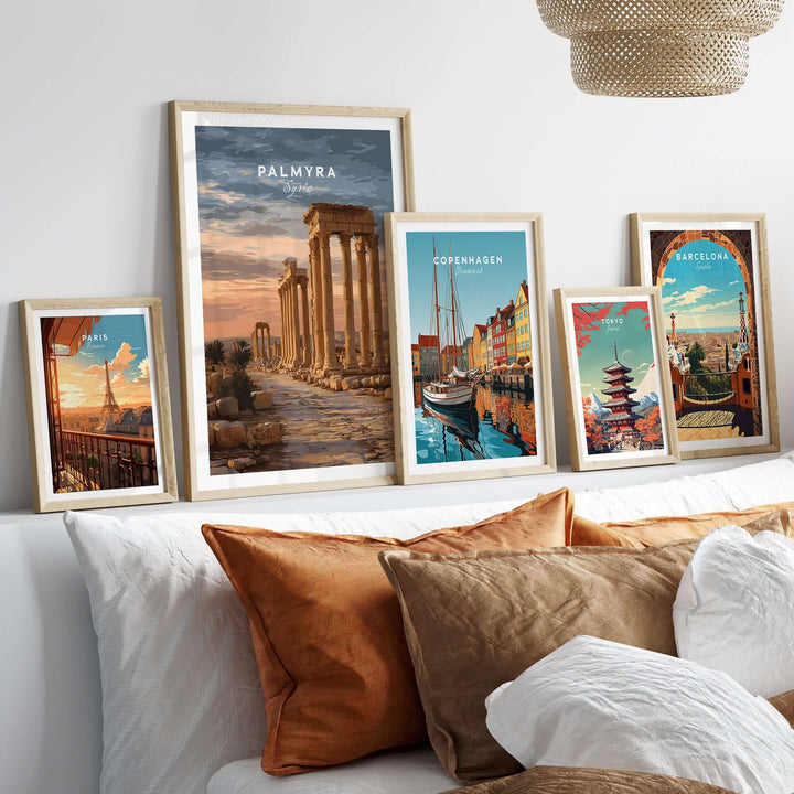 Framed Palmyra art print with Roman columns and other city posters on a stylish sofa, showcasing elegant wall decor.