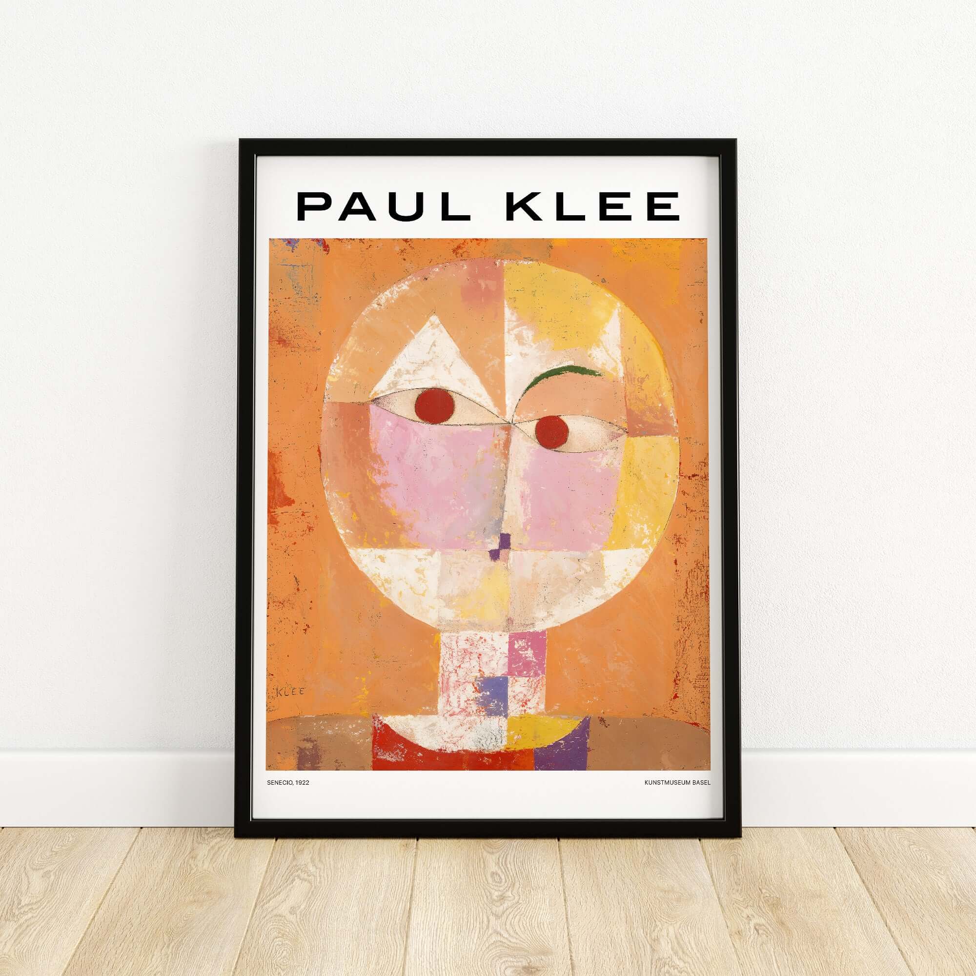 Paul Klee Senecio Head of Man Abstract Portrait Poster Art Print displayed in a black frame on a wooden floor.
