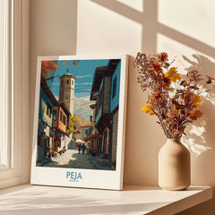 Peja Kosovo Old Town Street Art Print | Historic Tower View Poster displayed on a windowsill beside a vase of flowers.