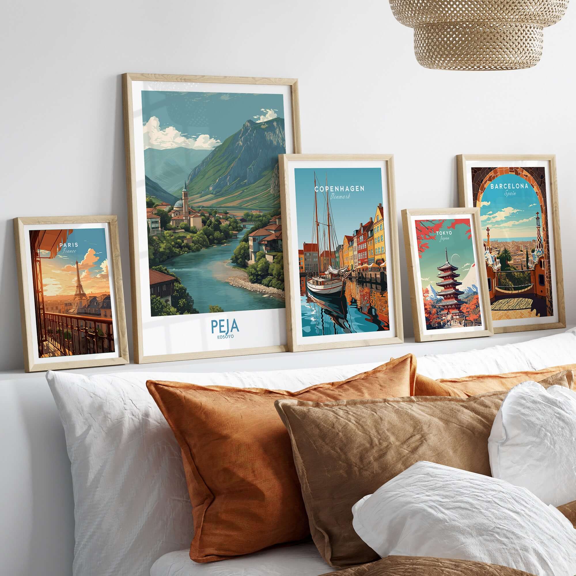 Peja Kosovo River Valley Art Print | Mountain Town Scenery Poster displayed among various city art prints on a cozy couch.