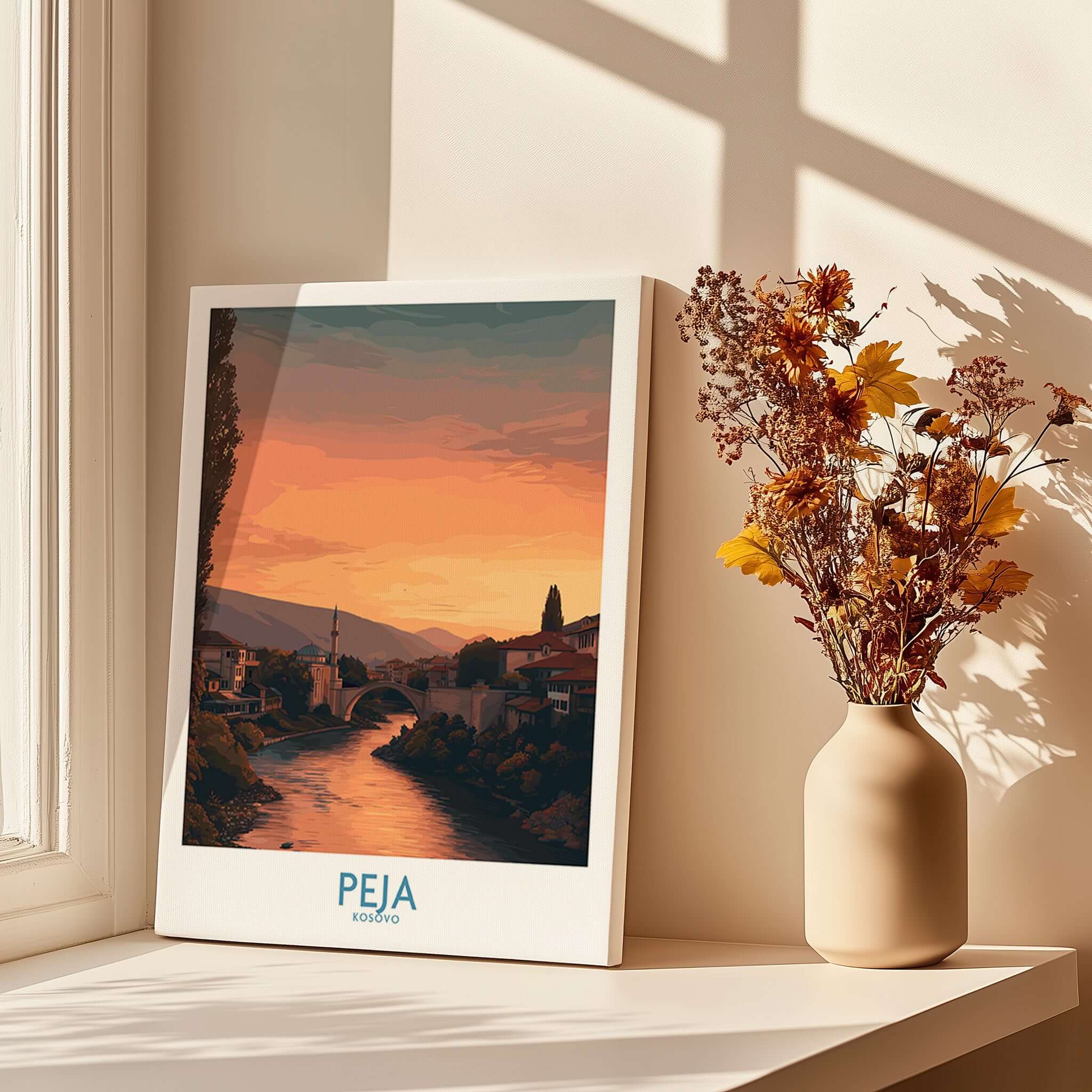 Peja Kosovo Sunset River Bridge Art Print | Mosque and Mountains Poster displayed beside a vase with flowers.
