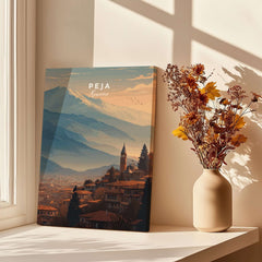 Peja Red Rooftops and Snow Mountain Canvas Print | Balkan Travel Decor displayed in a bright room with flowers.