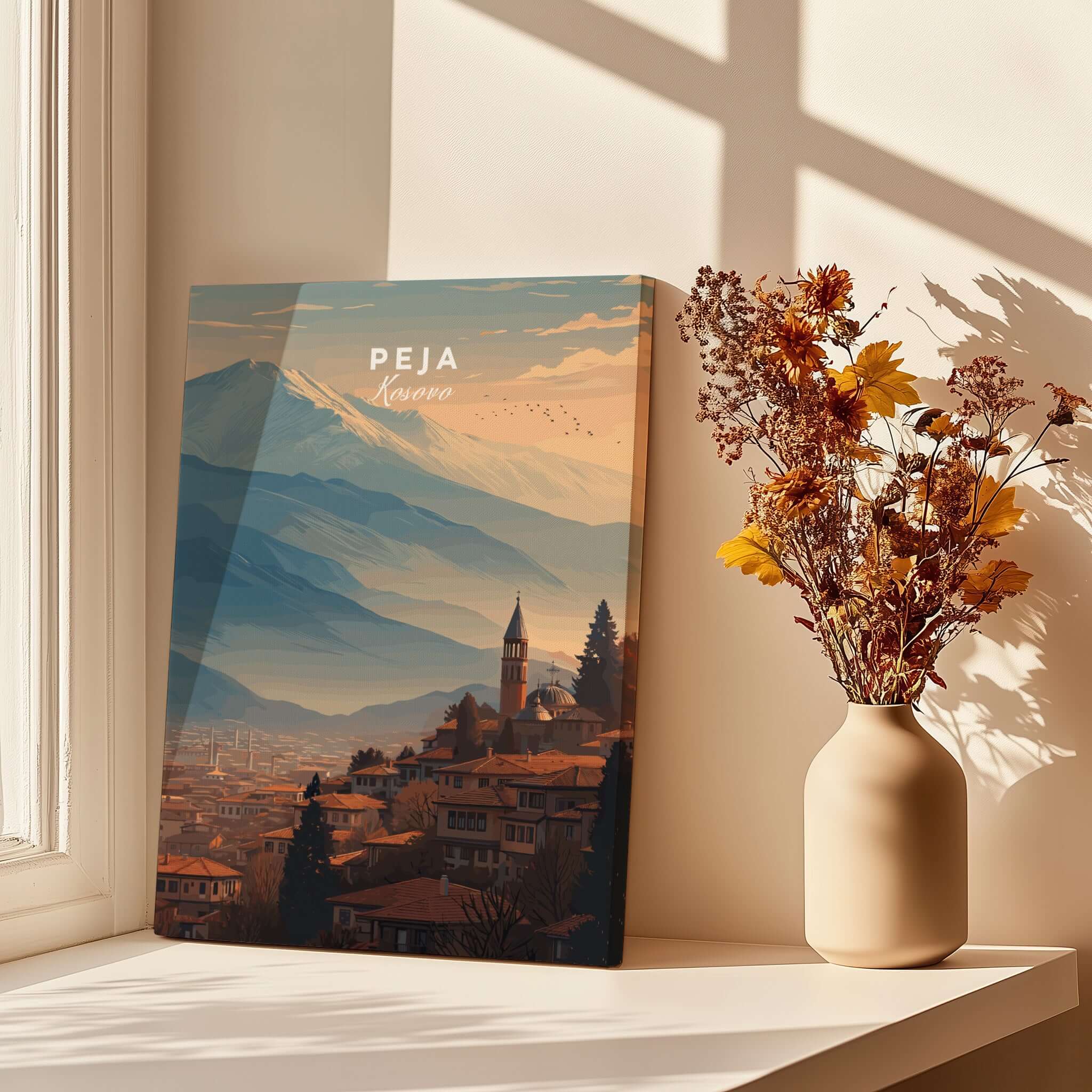 Peja Red Rooftops and Snow Mountain Canvas Print | Balkan Travel Decor displayed in a bright room with flowers.