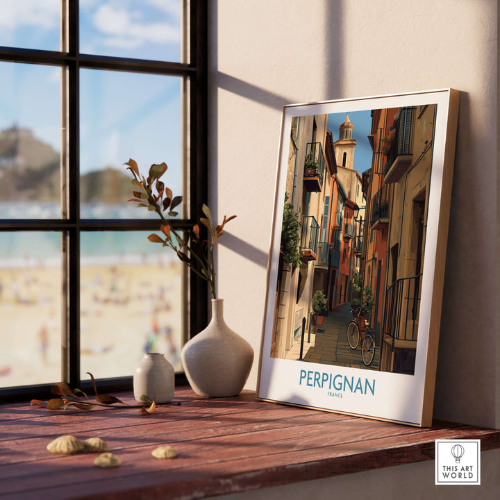 Perpignan poster framed on a wooden table, showcasing charming French architecture and scenic views of France.