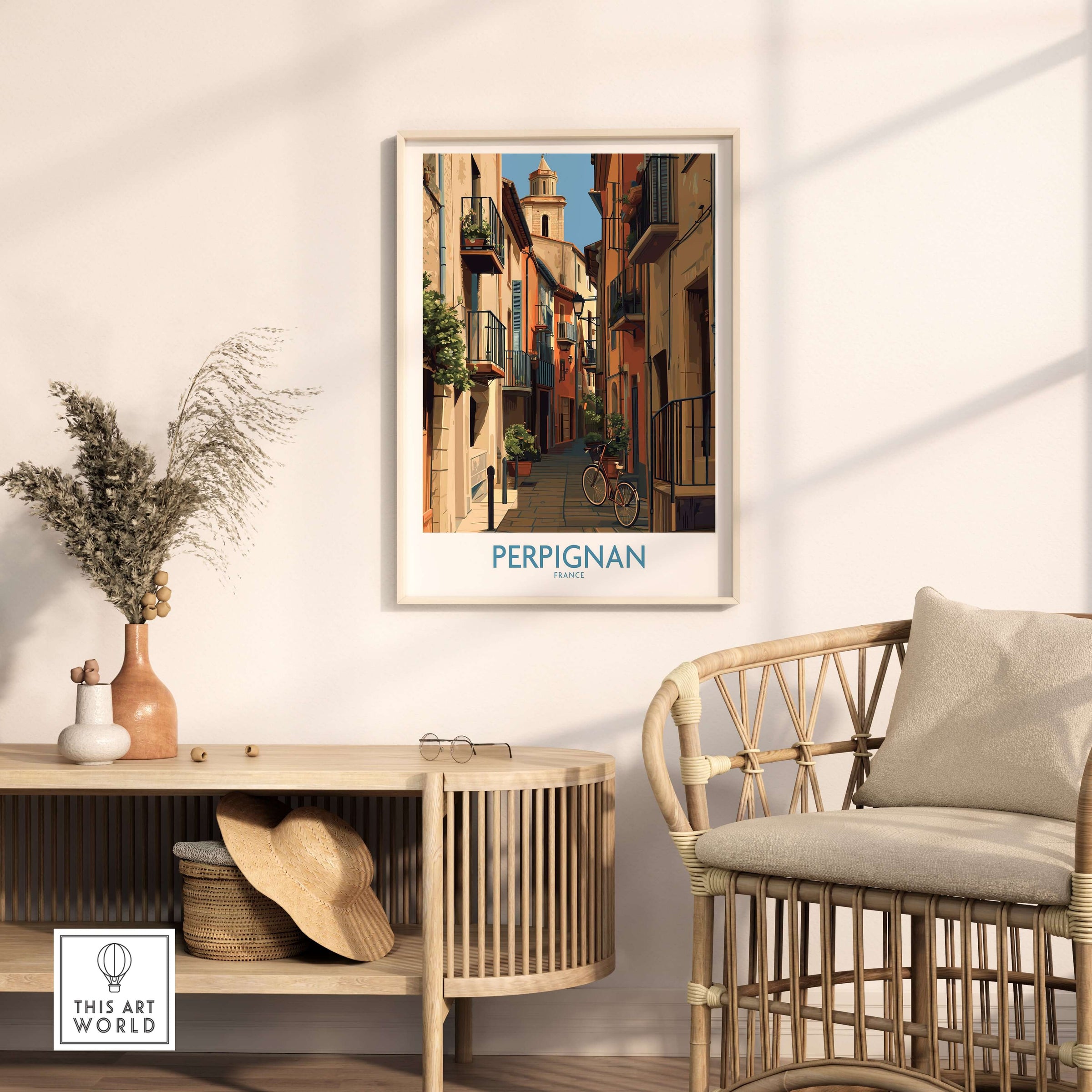 Perpignan Poster - France Travel Print - French Wall Art displayed on a wall near a rattan chair and decorative items.
