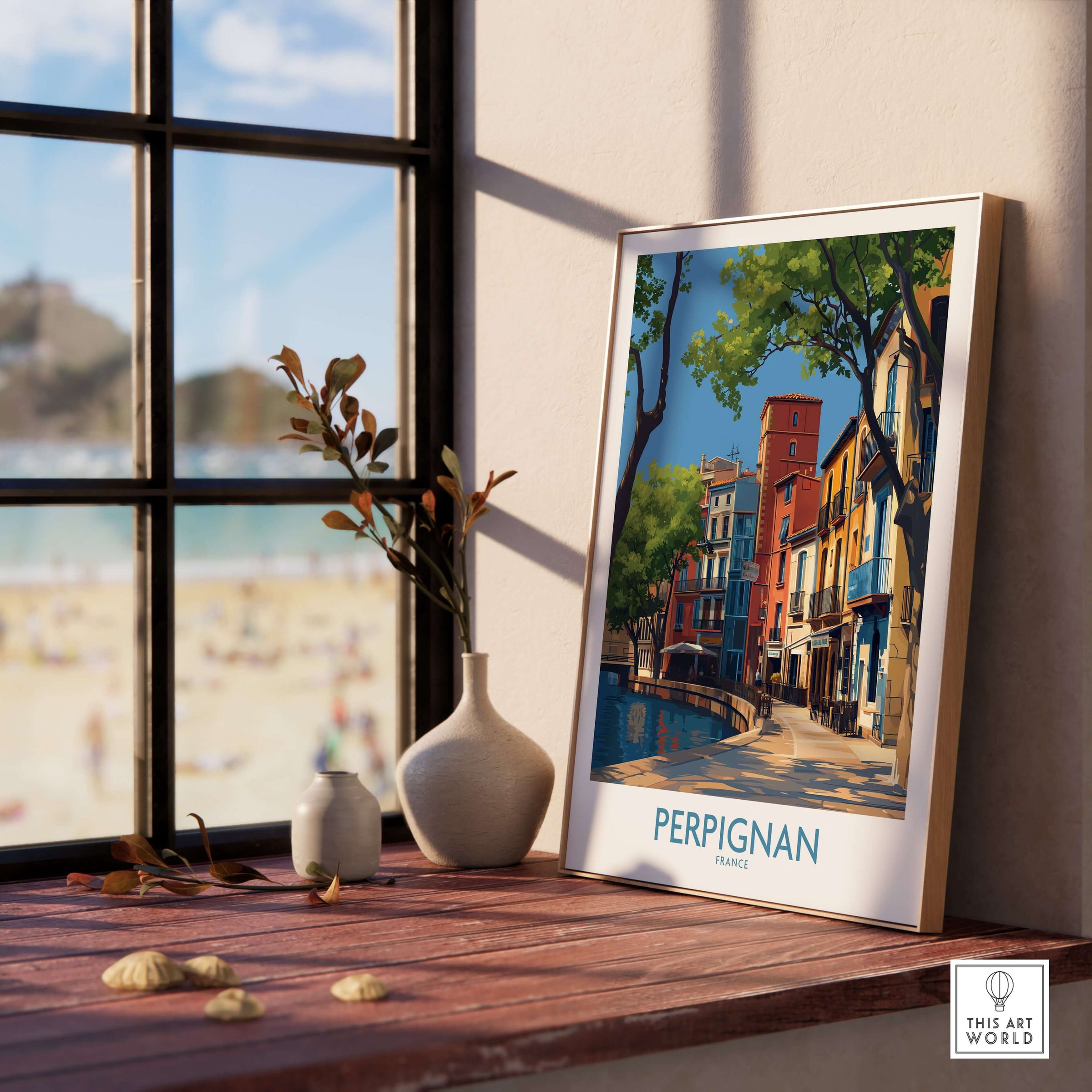 Perpignan Poster - France Travel Print - French Buildings Wall Art showcased on a wooden table near a window.