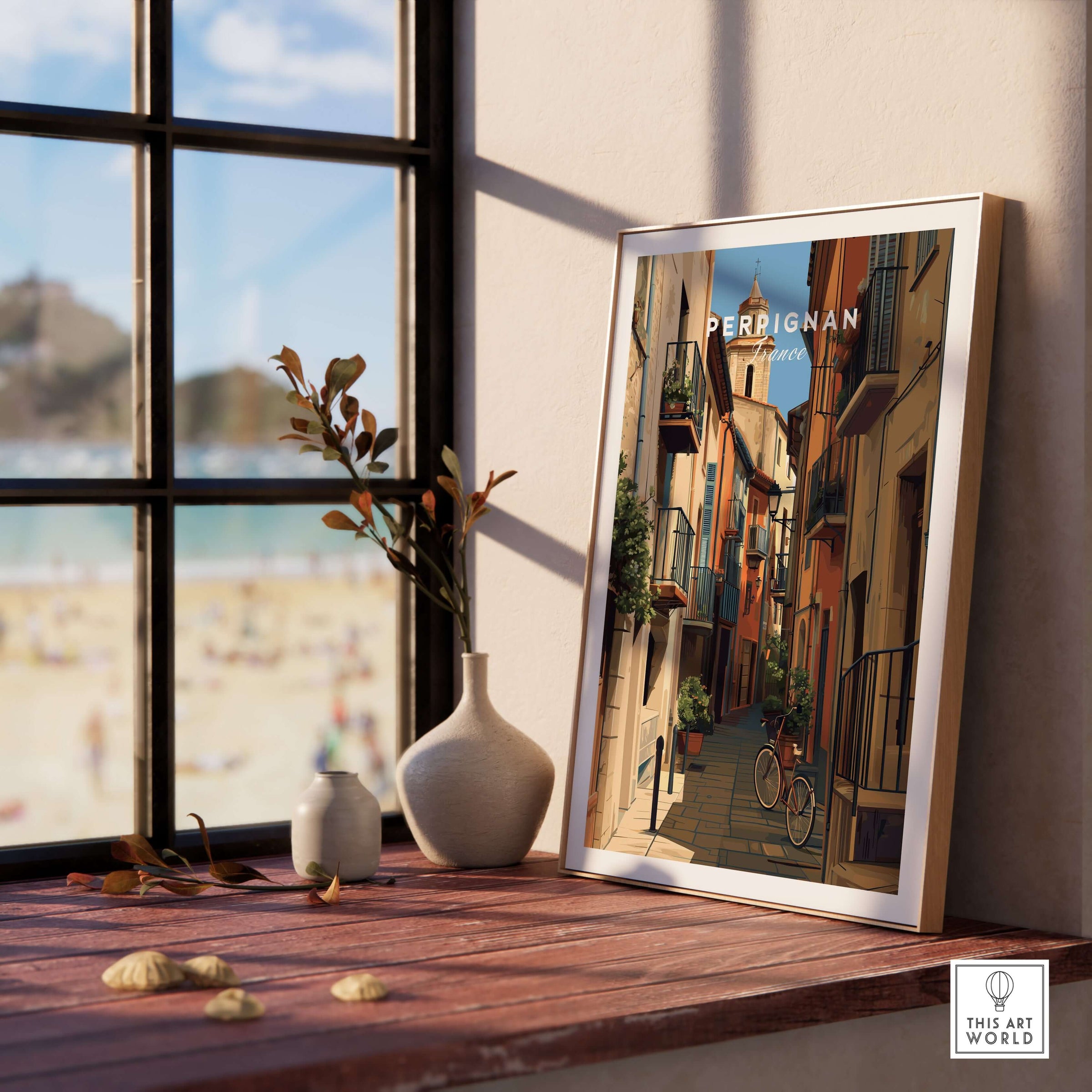Perpignan Poster - French Village Art Print - Wall Decor displayed on a table near a window with a beach view.