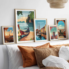 Phuket Print displayed among other travel art prints on a stylish sofa with decorative pillows.