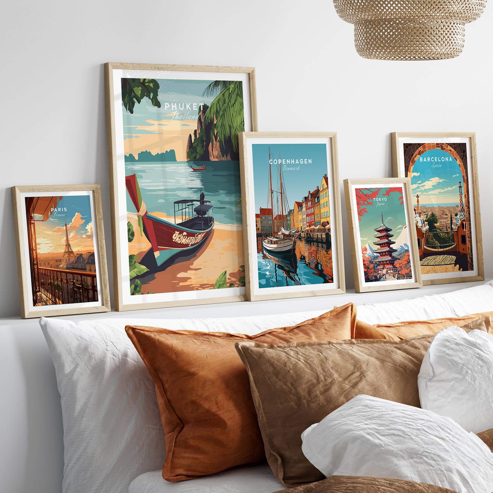 Phuket Print displayed among other travel art prints on a stylish sofa with decorative pillows.