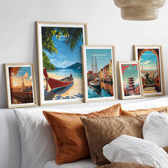 Phuket Travel Print displayed among various travel posters in a stylish home setting, showcasing vibrant tropical art.