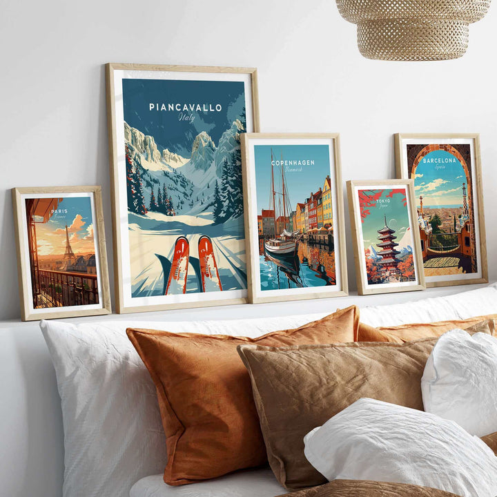 Collection of framed travel posters featuring Piancavallo Ski Poster, Italy, displayed on a wall above a sofa.