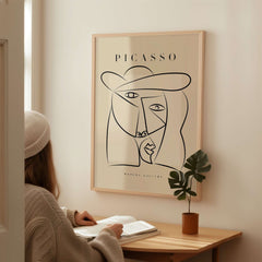 Picasso Abstract Face Hat Line Art Minimalist Portrait Poster Print Modern Gallery displayed on wall above a girl reading.